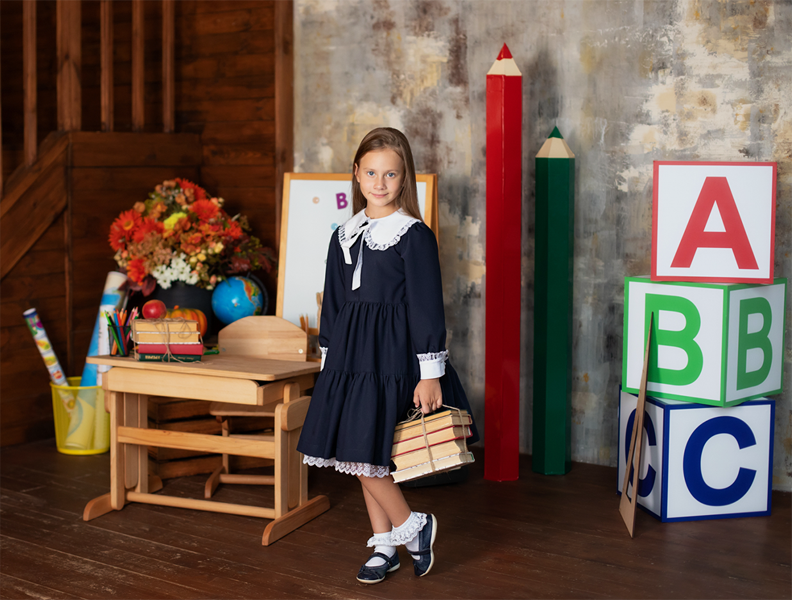 girl posing for picture with school back drop